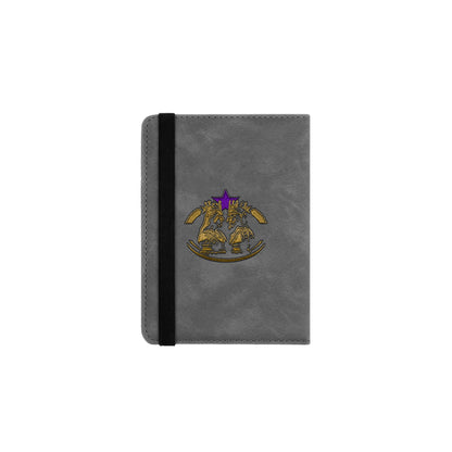 A gray passport cover with a purple and gold logo on the front.